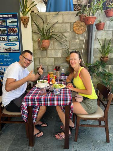a man and woman sitting at a table eating food at Phuoc Dat Riverside Homestay Hoi An in Hoi An