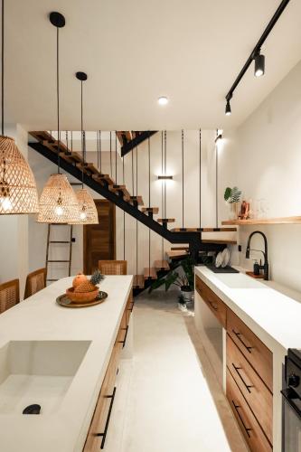 a kitchen with white countertops and a staircase at Terra Villas in Ahangama