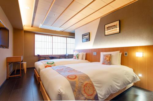a hotel room with two beds and a television at Gion Misen in Kyoto