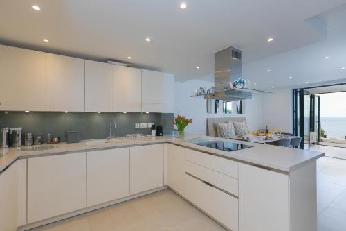 a kitchen with white cabinets and a large window at Monowai Heights in St Ives