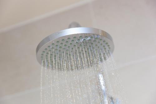 a shower with a shower head with water at Monowai Heights in St Ives