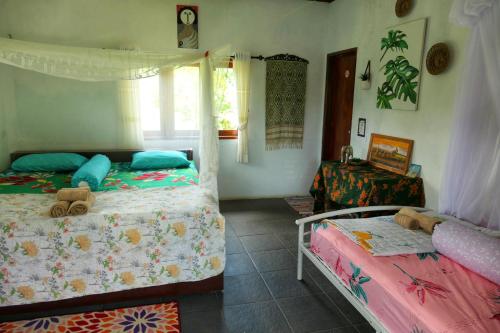 a bedroom with two beds and a window at Sumatra Orangutan Discovery Villa in Bukit Lawang