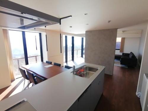 a kitchen with a sink and a table in a room at Aki's Apartments Madarao in Iiyama