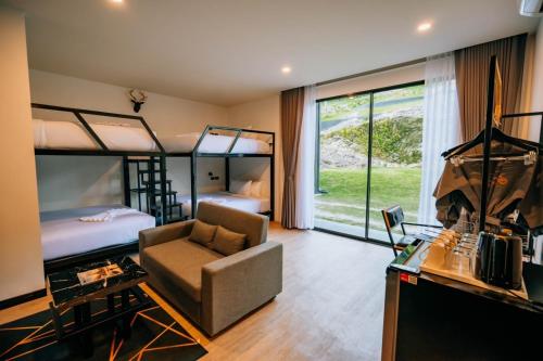 a room with two bunk beds and a chair and a desk at D’Endless Resotel in Baen