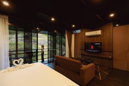 a bedroom with a bed and a chair and a television at D’Endless Resotel in Baen