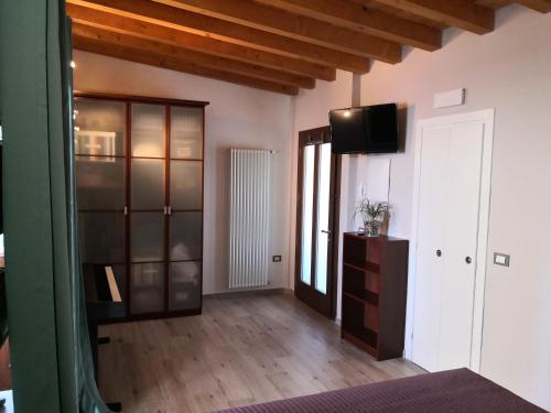 ein Wohnzimmer mit einem TV und Holzböden in der Unterkunft Note di lago in Manerba del Garda