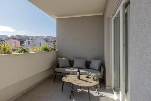 un balcone con divano e tavolo su un edificio di 6 Islands - Holiday & Business Apartments - free garage parking a Spalato (Split)