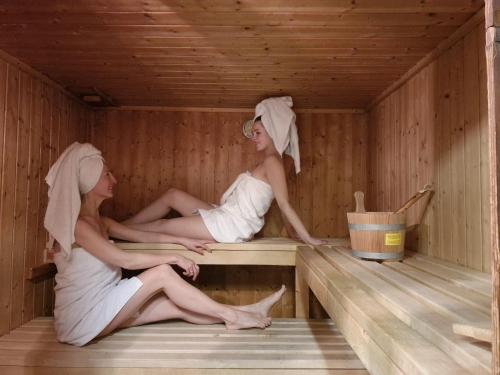 two women sitting in a sauna at KNAUS Campingpark Viechtach in Viechtach