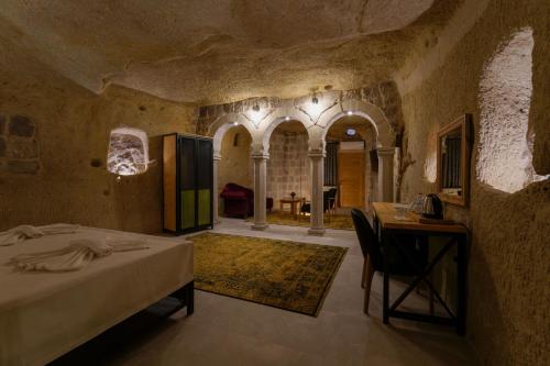 a bedroom with a bed and a table in a room at The Niche Cave Hotel in Goreme