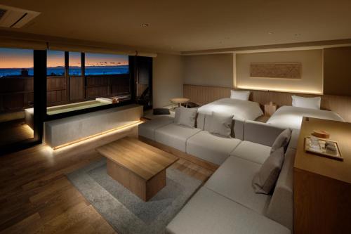 ein Schlafzimmer mit einem Bett und einem Sofa und ein Zimmer mit Aussicht in der Unterkunft Atarayo Nishiizu Onsen in Izu