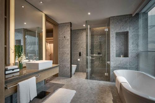 a bathroom with a tub and a sink and a shower at The QUBE Hotel Shanghai Hongqiao in Shanghai