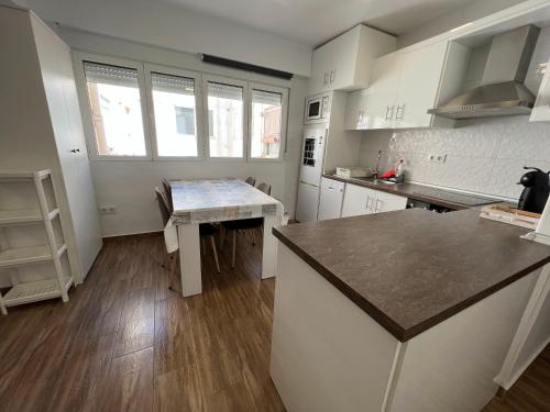 uma cozinha com armários brancos e uma bancada em Apartamento Zapillo a 3 minutos de la playa em Almeria