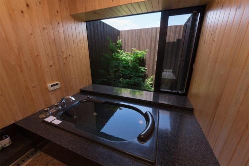 baño con lavabo negro y ventana en 満天の庭 Manten-no-niwa, en Kurume