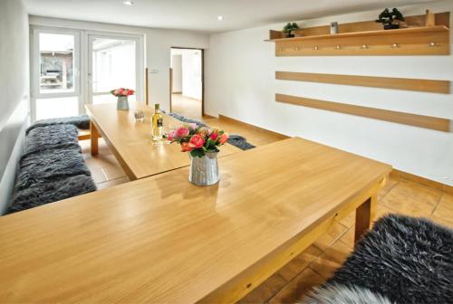a dining room with a wooden table with flowers on it at Chaloupka víno sklep U Palečků in Zaječí