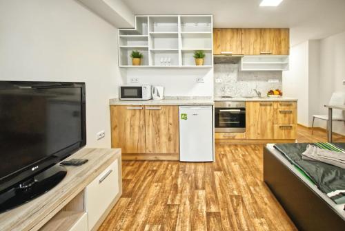 a kitchen with wooden cabinets and a white refrigerator at Chaloupka víno sklep U Palečků in Zaječí