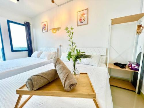 ein Schlafzimmer mit zwei Betten und einer Vase auf einem Tisch in der Unterkunft J Cozy 1-5pax Trefoil Setia Alam 100Mps Wifi & TV in Kuala Selangor