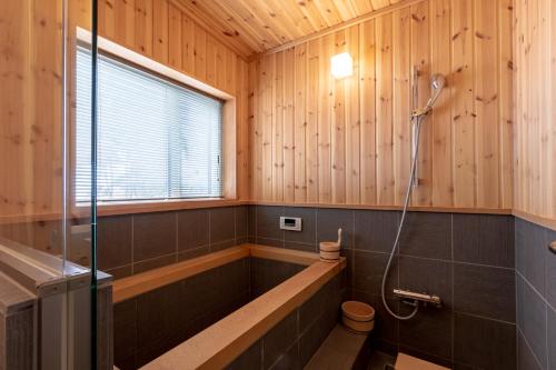 a bathroom with a shower and a toilet in it at Owl House Niseko in Niseko