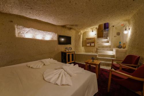 a bedroom with a bed with towels on it at The Niche Cave Hotel in Goreme