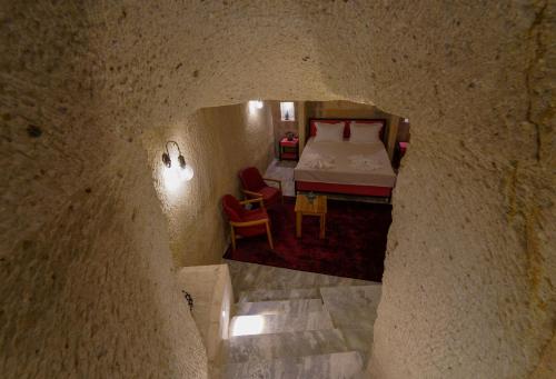 a bedroom with a bed in a stone wall at The Niche Cave Hotel in Goreme