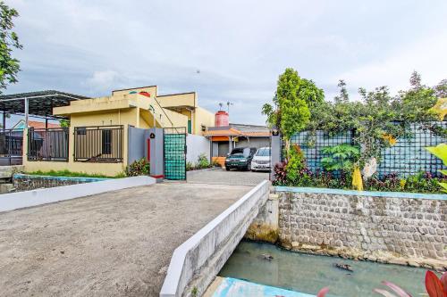een huis met een oprit en een hek bij OYO 92296 Amole Paviliun Syariah in Cilacap
