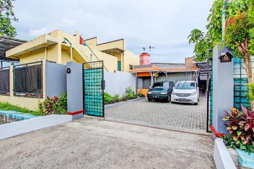 a gate to a house with a car parked in a parking lot at Hotel O Amole Paviliun Syariah in Cilacap