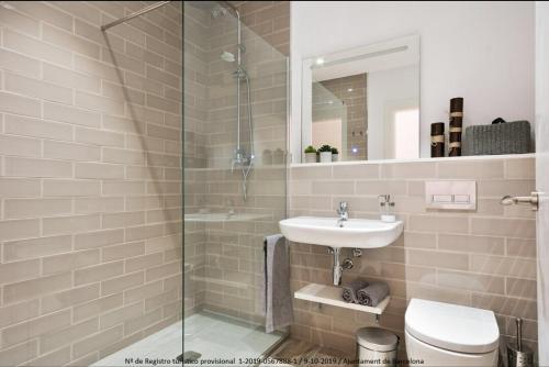 a bathroom with a sink and a glass shower at Design Apartments Plaza Catalunya in Barcelona