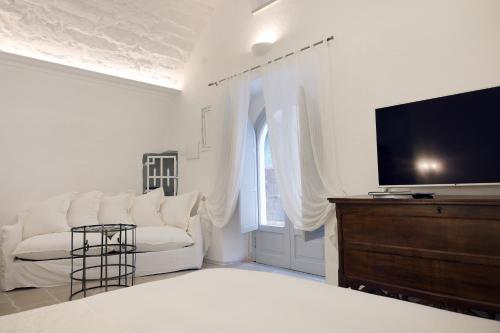 ein Wohnzimmer mit einem weißen Sofa und einem Flachbild-TV in der Unterkunft dimore di portadibasso in Peschici