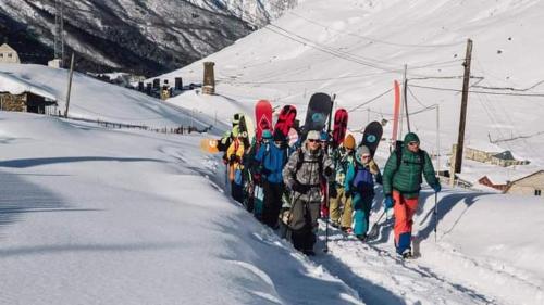 a group of people standing in the snow with snowboards at Vila Latphari in Ushguli in Ushguli