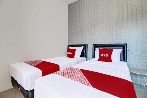 two beds with red and white sheets in a room at Super OYO Collection O 92363 Kp Inn in Yogyakarta