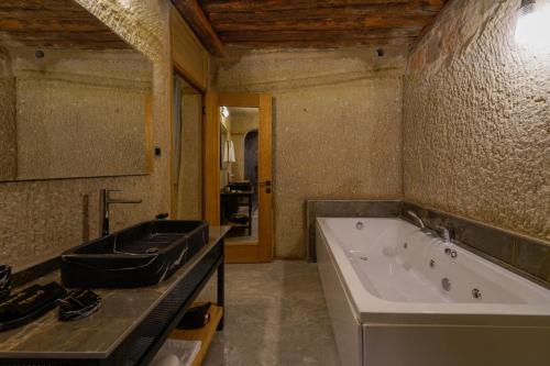 a large bathroom with a tub and a sink at The Niche Cave Hotel in Goreme