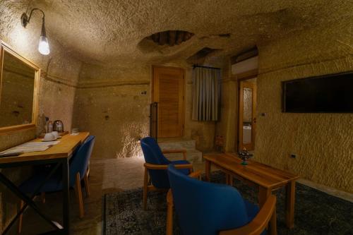 a dining room with a table and chairs and a television at The Niche Cave Hotel in Goreme