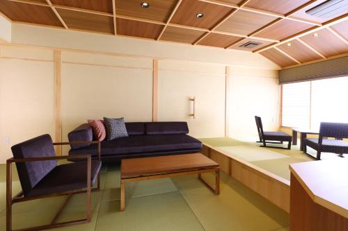 a living room with a couch and two chairs at Hotel Tamanoyu in Matsumoto