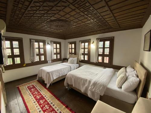 a bedroom with two beds and a couch and windows at Ebrulu Konak in Safranbolu