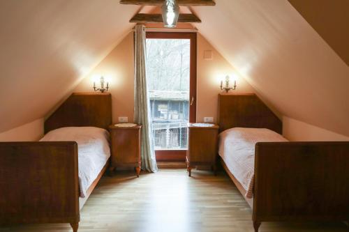 a attic bedroom with two beds and a window at Country house with a pool in Medvednica Nature Park in Zagreb