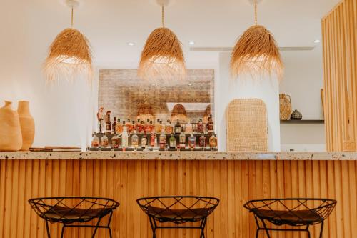 a bar with four chairs and a picture on the wall at Palm Boutique H&ocirc;tel Nice in Nice