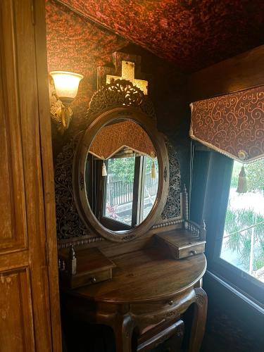 a mirror on top of a wooden table in a room at Bantunglom Resort in Mae Rim