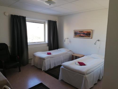 a hotel room with two beds and a window at Hotell Hemgården in Bengtsfors