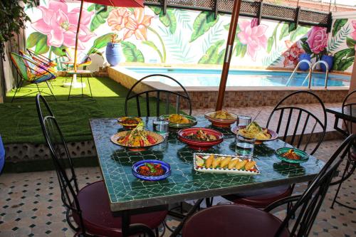 una mesa con platos de comida encima en Majorel Perle Hôtel Riad Restaurant Picine & Spa en Marrakech