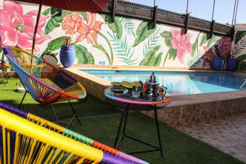 uma piscina com cadeiras e uma mesa com bebidas em Majorel Perle Hôtel Riad Restaurant Picine & Spa em Marrakech