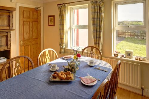 a table with a blue table cloth and a plate of food at Glencarrig B&B in Carrigaholt