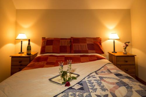 a bedroom with a bed with two lamps and flowers on it at Glencarrig B&B in Carrigaholt