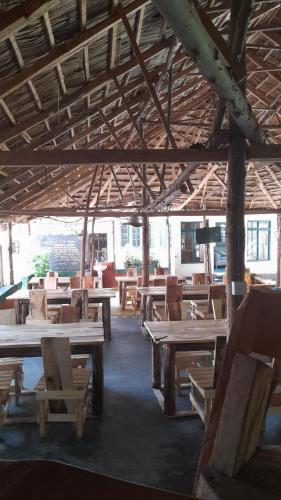 a room with wooden tables and chairs in a building at Green Garden Hostel in Arusha