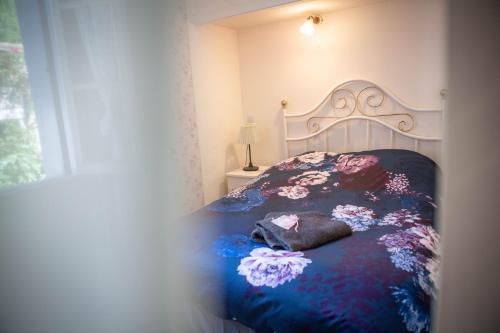 a bedroom with a bed with a blue and purple blanket at La Roseraie in Lodève