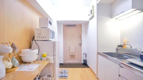 La cuisine est équipée d'un évier et d'un réfrigérateur. dans l'établissement TOKYO ICHIBAN SHINJUKU, à Tokyo
