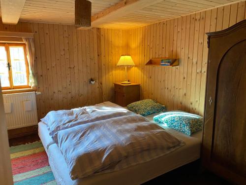 a bedroom with a bed and a lamp in it at Roubenka u potoka Jizerské hory in Desná