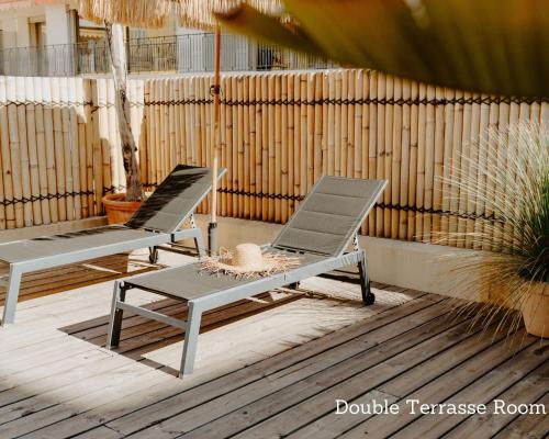 two lounge chairs and a table on a patio at Palm Boutique Hôtel Nice in Nice