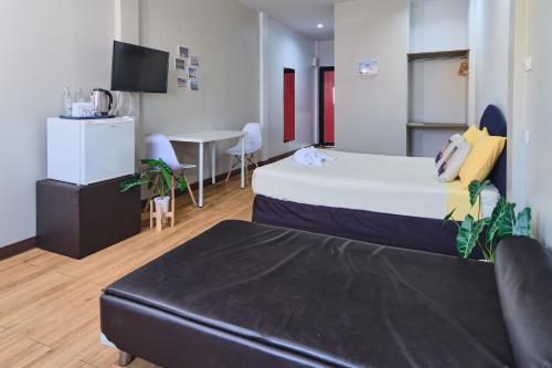 a hotel room with a bed and a couch at Bkk39 Airport hotel in Ban Khlong Prawet