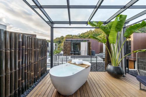 a bathroom with a bath tub on a deck at Deer Chaser Hotel in Yuchi