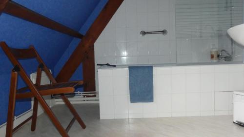 a kitchen with a counter and a chair in a room at Le Pressoir in Beaumesnil