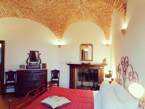 a bedroom with a red bed and a fireplace at Residenza Le Peonie in Todi